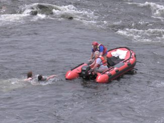 Rescue workers pull teens from river using boat