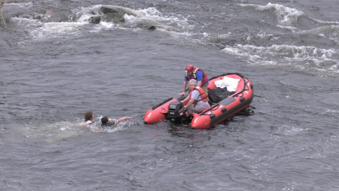 Rescue workers pull teens from river using boat